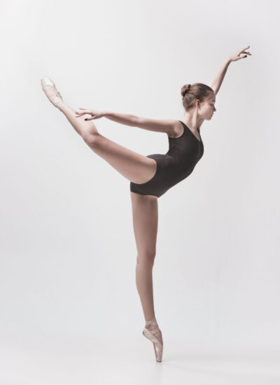 Young classical dancer dancing on white background. Ballerina project.